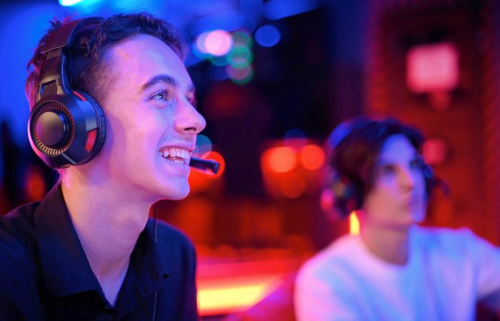 two-teen-friends-headphones-are-playing-game-console-using-gamepads-smiling1